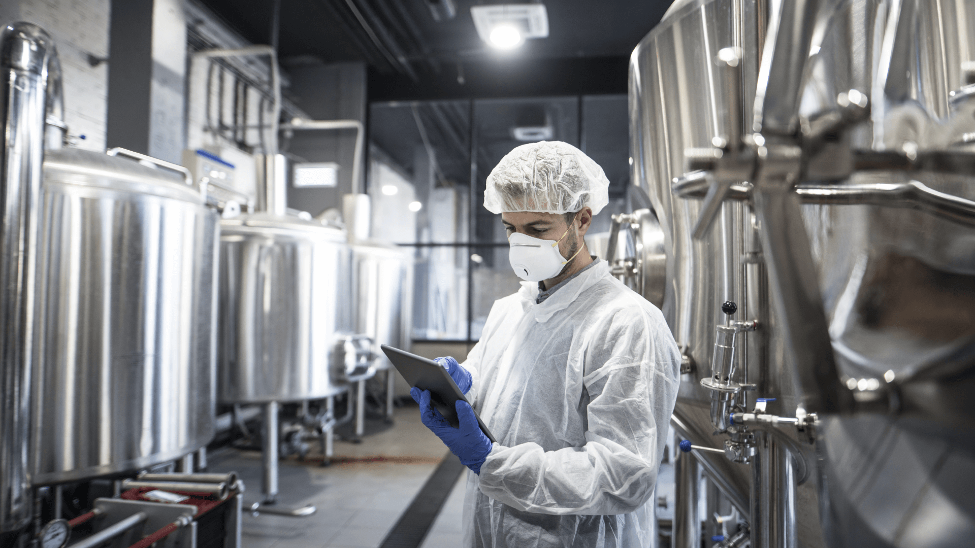 Person at work in a factory looking at a tablet device 